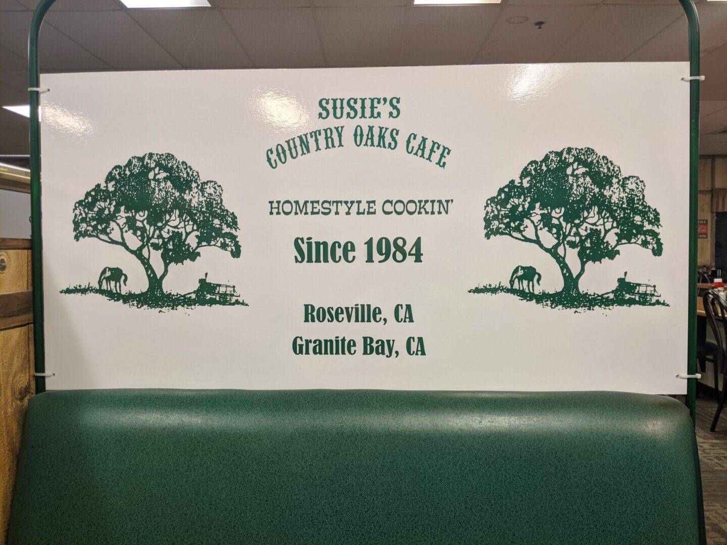 A bench with the name susie 's country cake cafe on it.