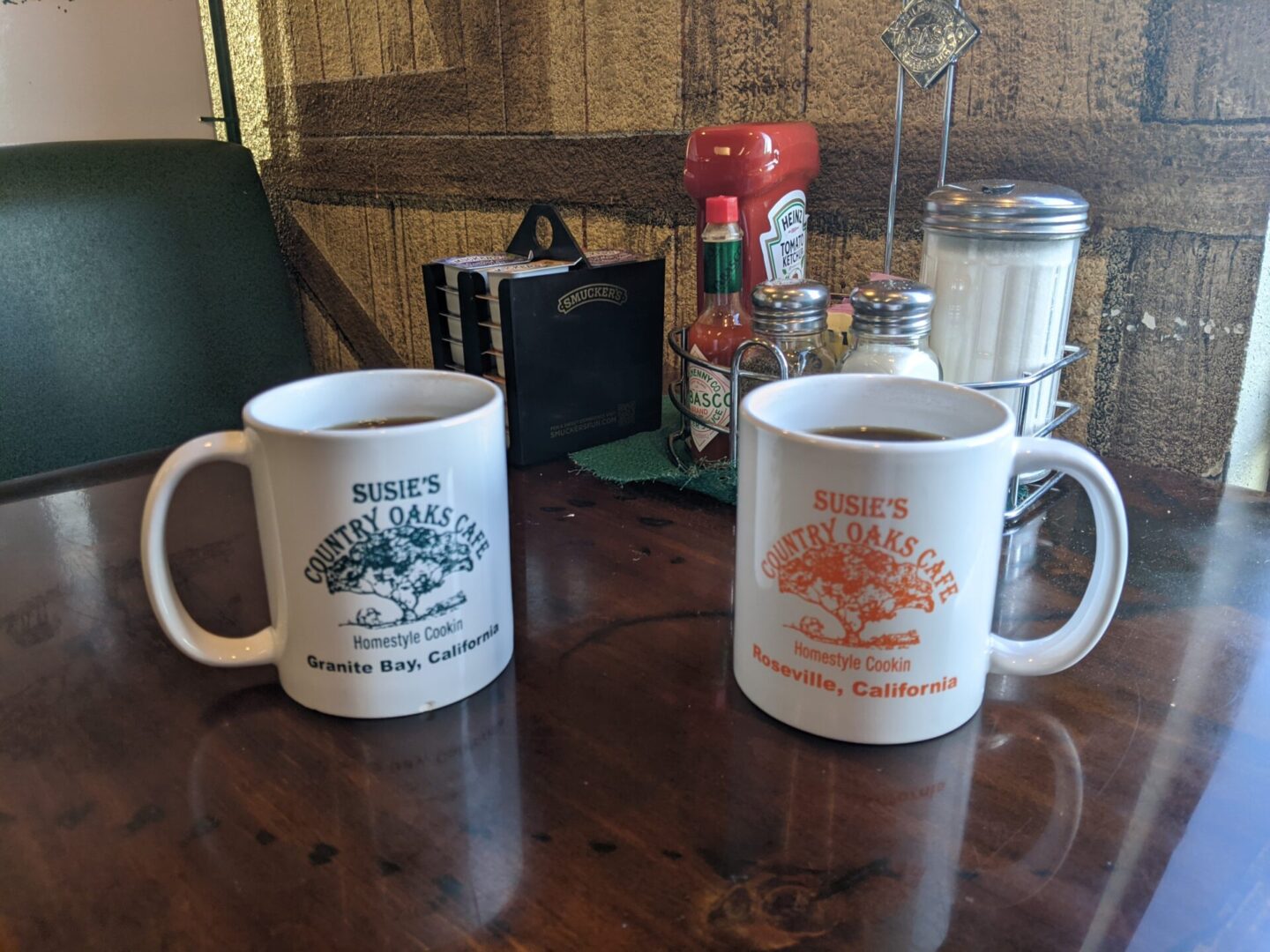 Two coffee cups sitting on a table with other items.