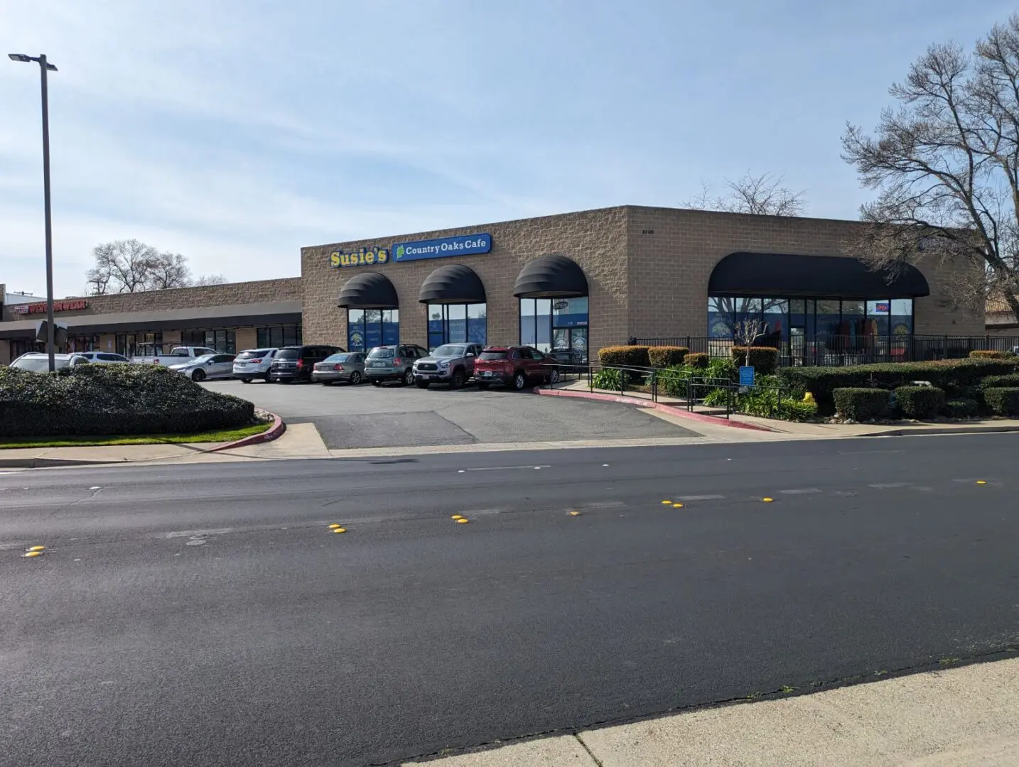 A large building with many windows and cars parked in front of it.